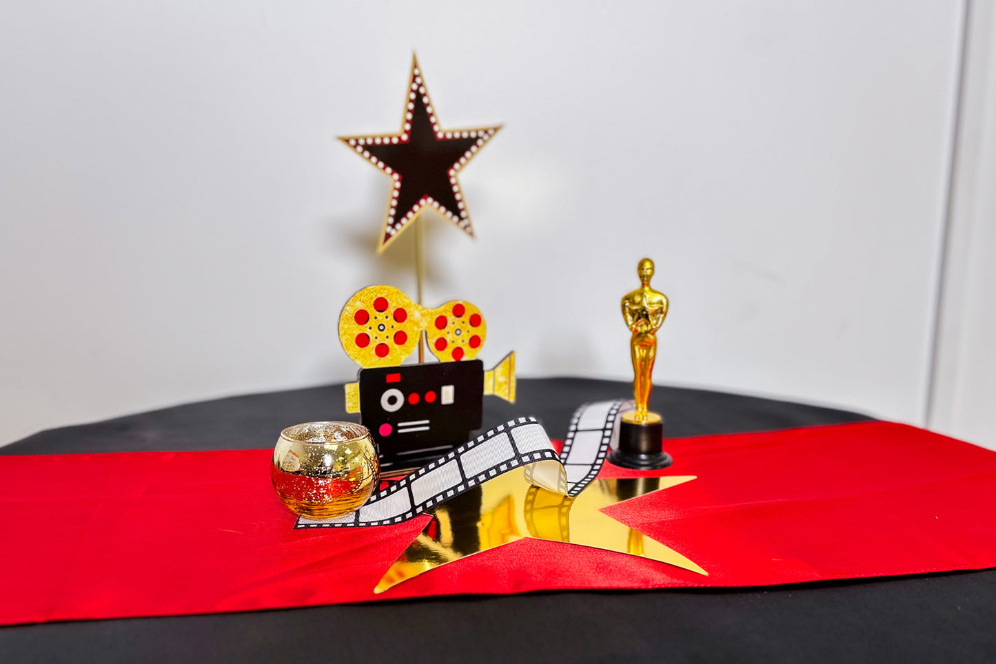Decorative Centrepiece with Oscar statue, star, and film reel on a red table runner