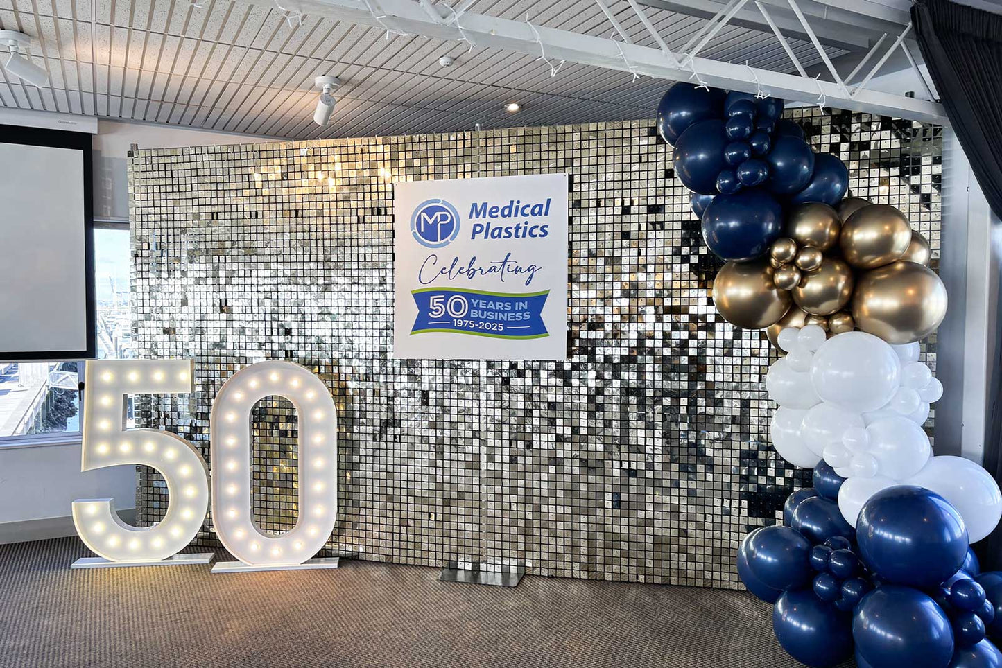 Decorative setup with custom sign and balloons, and large '50' sign.