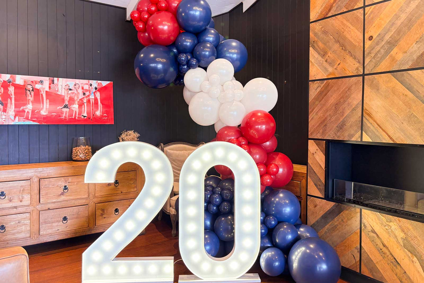 Custom balloon garland paired with marquee-style light-up numbers