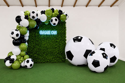 Game On soccer backdrop with green hedge wall, organic balloon garland, oversized soccer ball balloons and neon sign for World Cup parties and soccer-themed events in Auckland.