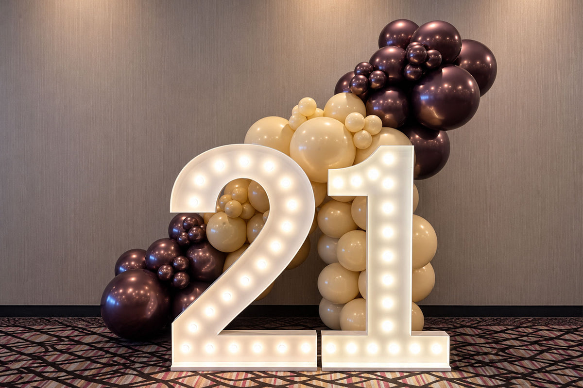 21 marquee lights with colourful balloon decorations at an event