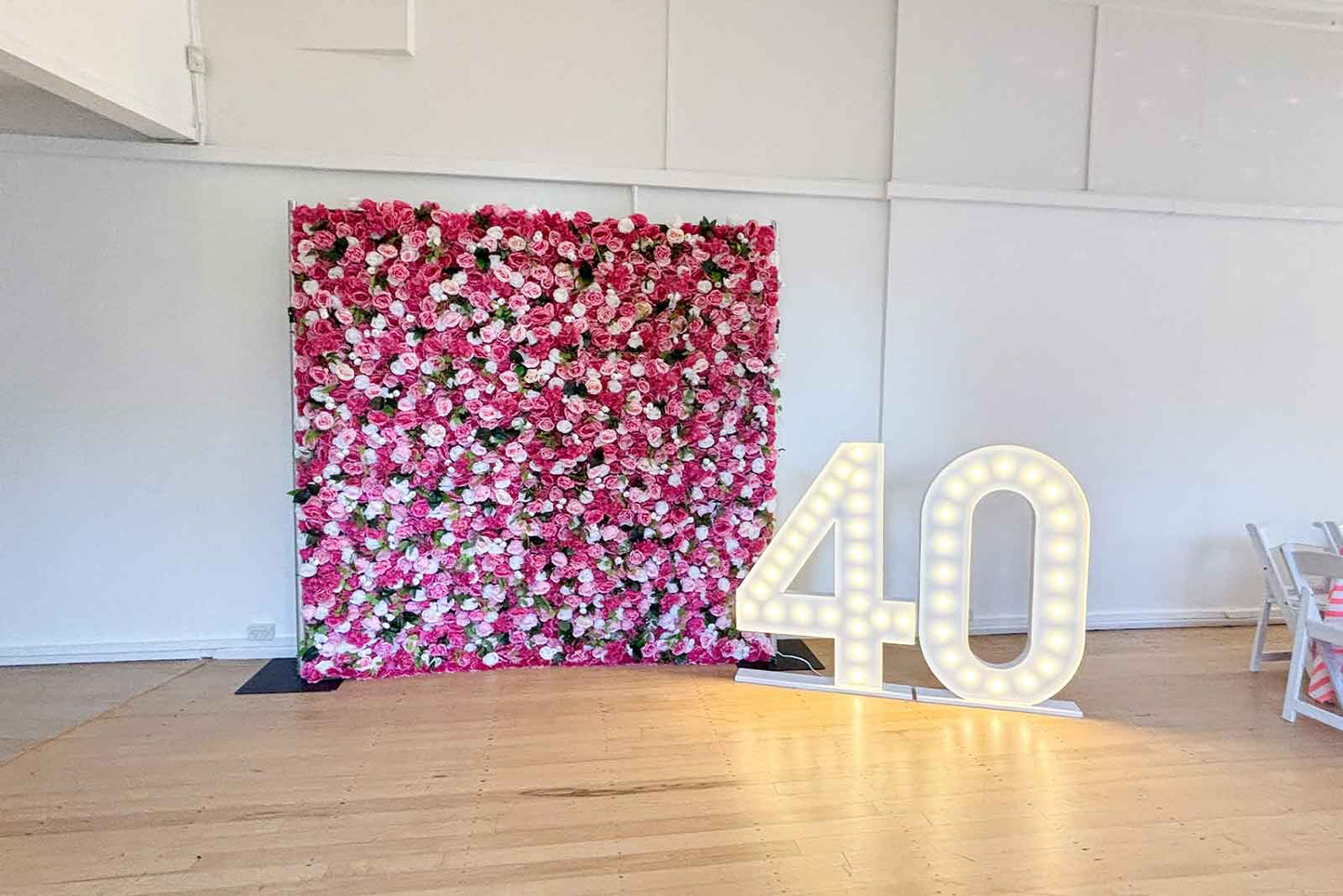 40 marquee lights in front of flower wall for event backdrop