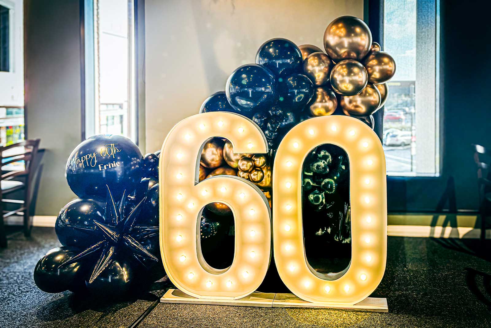 Party setup with 60 marquee lights and festive balloon garland for event photography