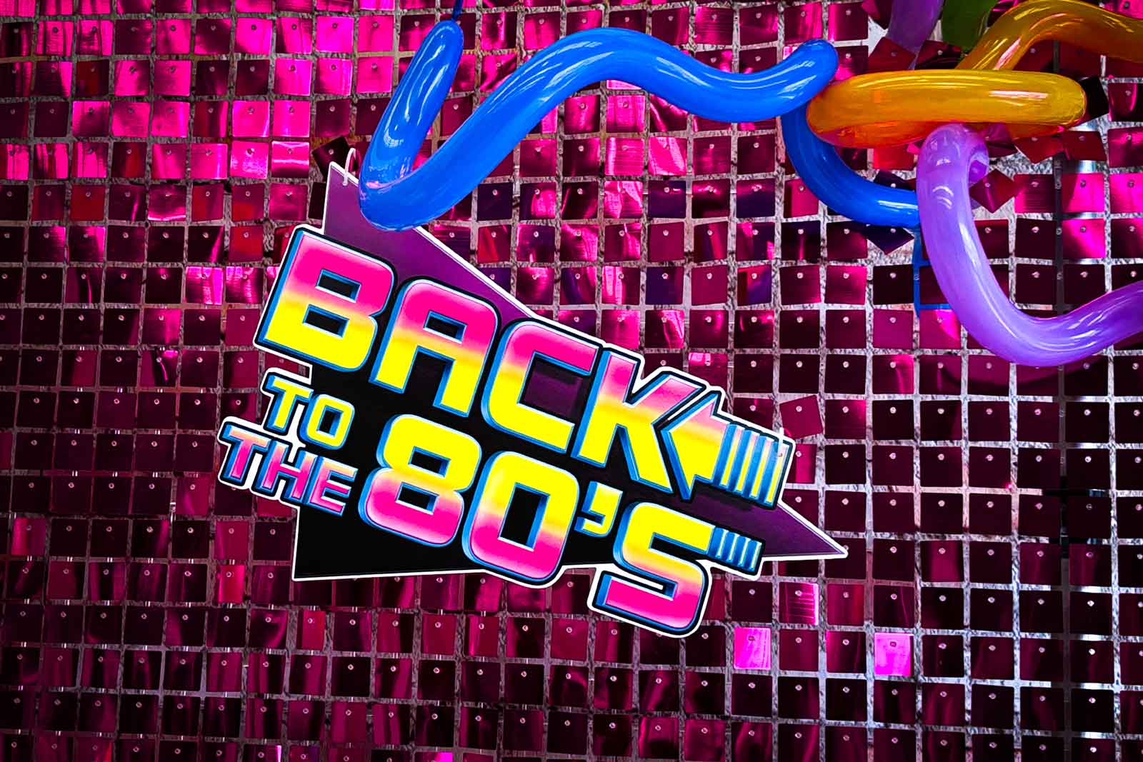 Retro 80s disco party backdrop with balloon décor for event hire