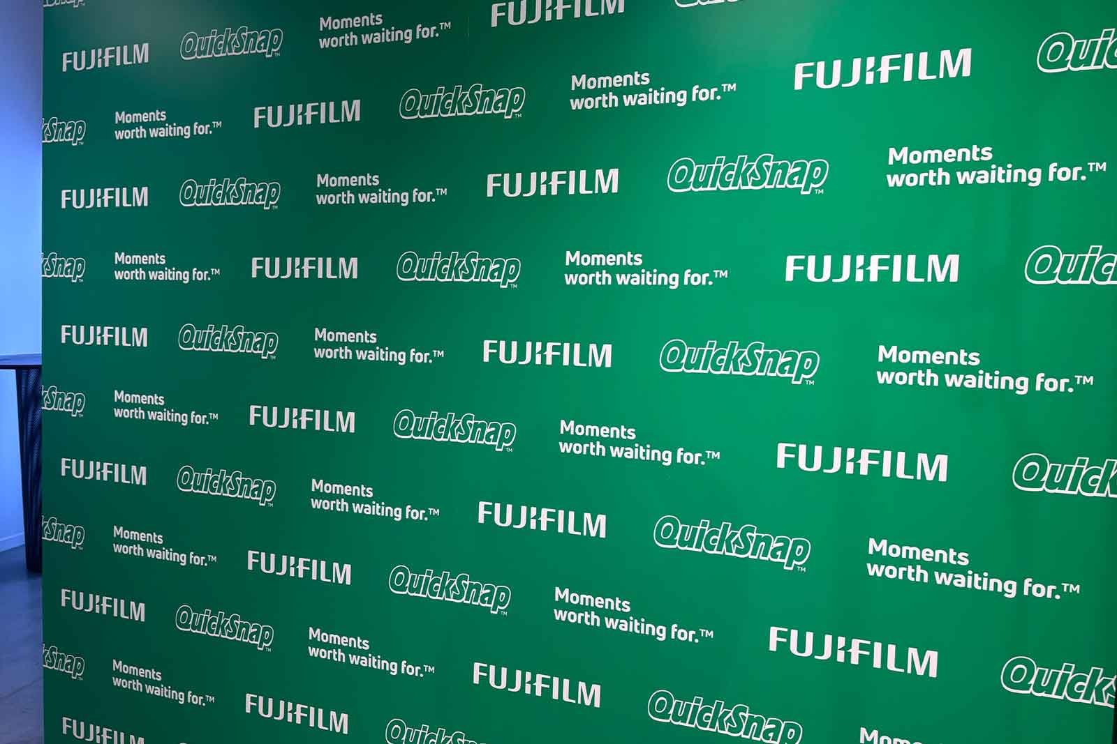 Green backdrop with repeated Media Wall