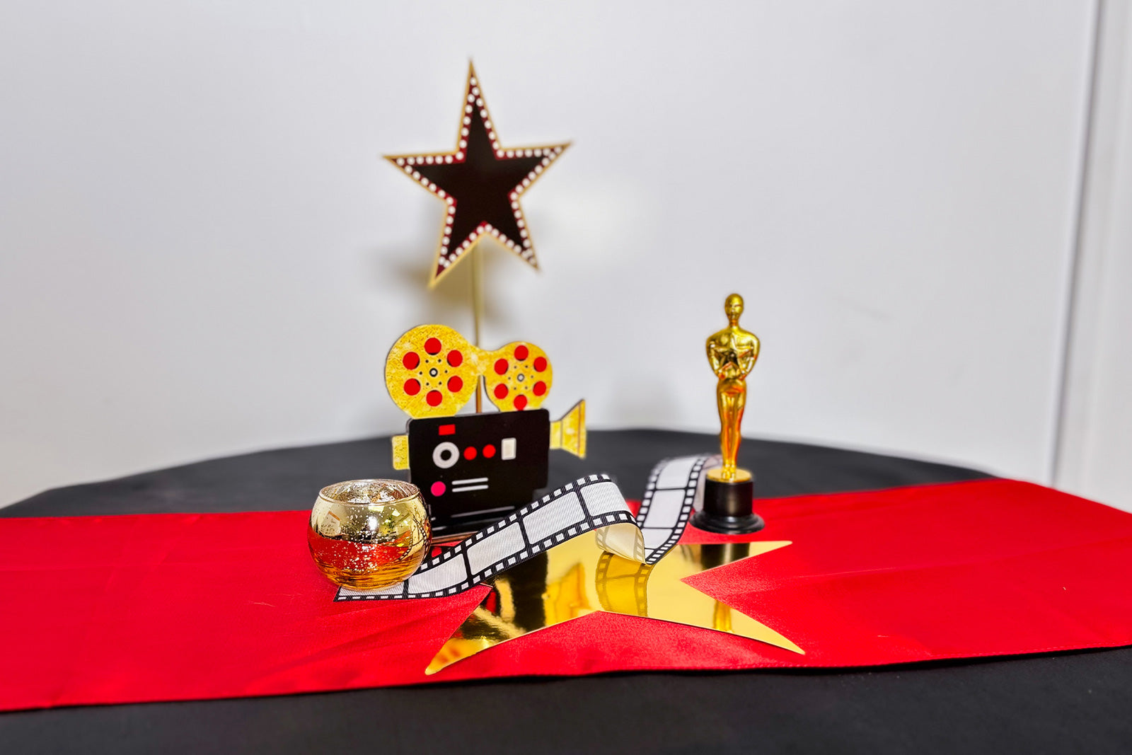 Decorative Centrepiece with Oscar statue, star, and film reel on a red table runner