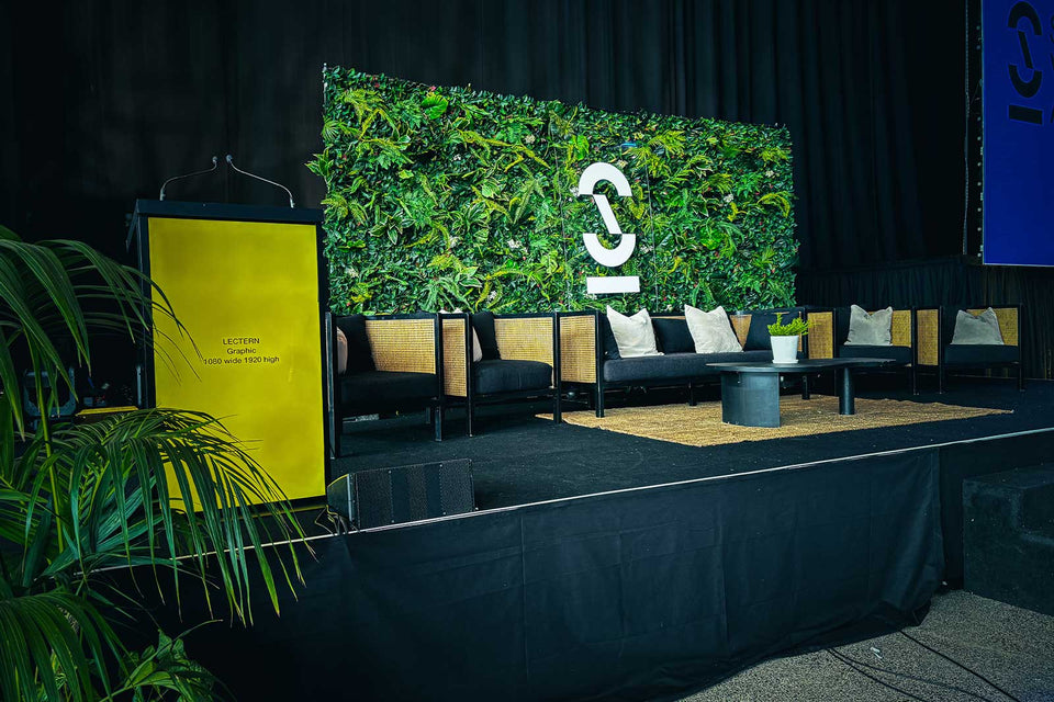 Event setup with Tropical Wall, seating area, and branded backdrop