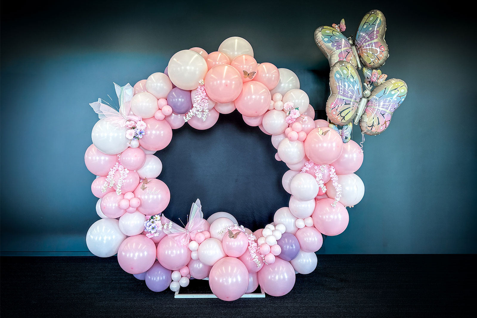 Balloon butterfly hoop display with pastel balloon garland and butterfly accents for event hire in Auckland