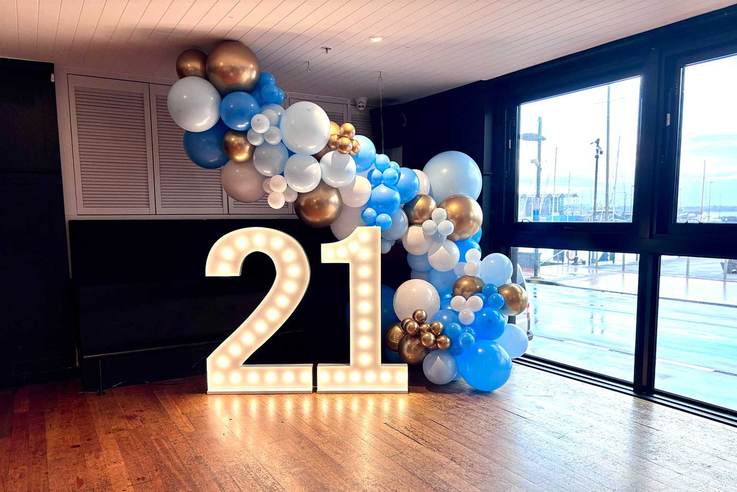 Balloon garland installation arranged around large illuminated number props
