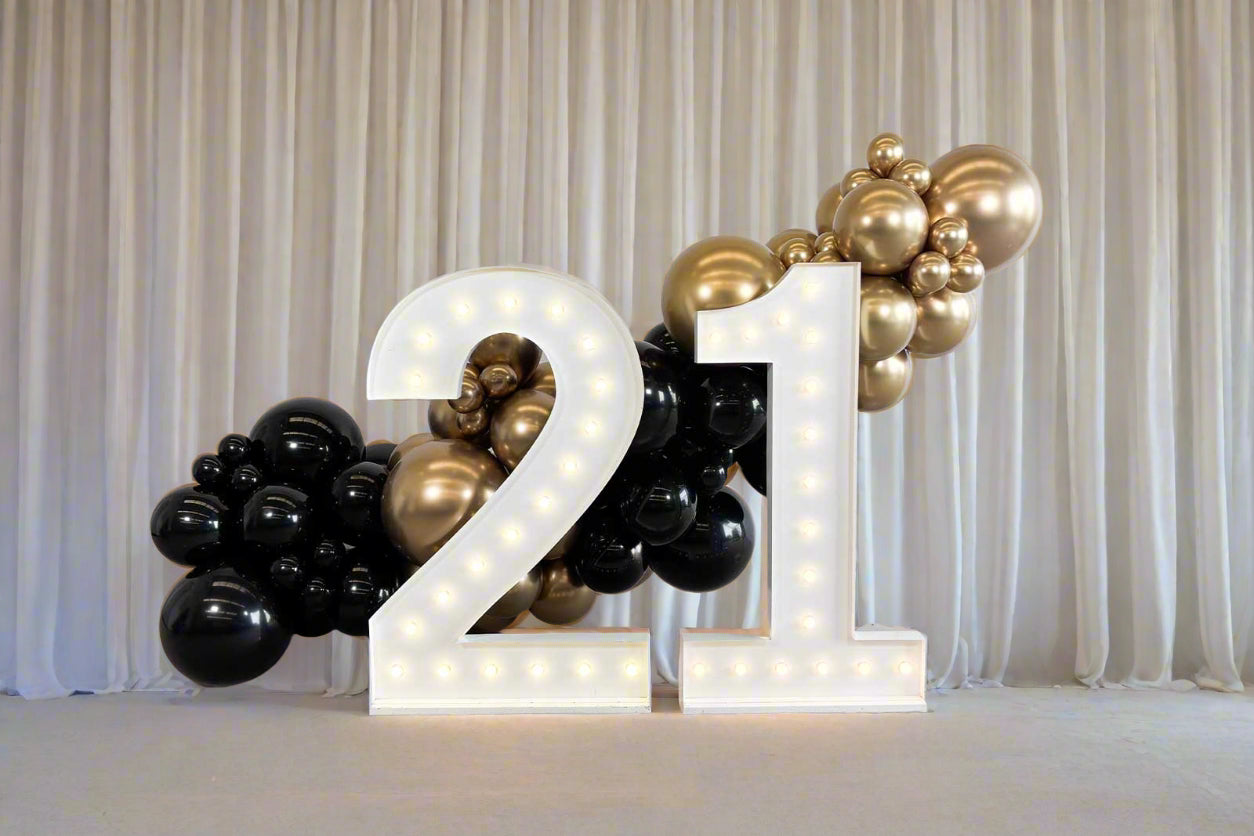 Birthday party décor with illuminated numbers and balloons