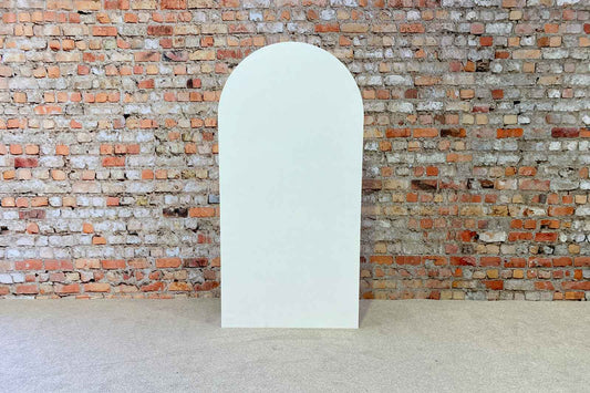 Clean white arch backdrop stand styled minimally for weddings, birthdays, and corporate events.