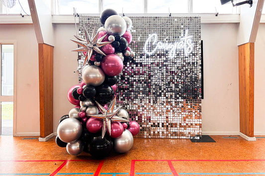 Congrats neon sign on silver shimmer wall with balloon garland