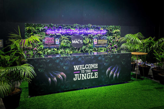 Luxury corporate tropical wall backdrop with lush green foliage, custom branding and event styling for conferences, product launches and business functions in Auckland.