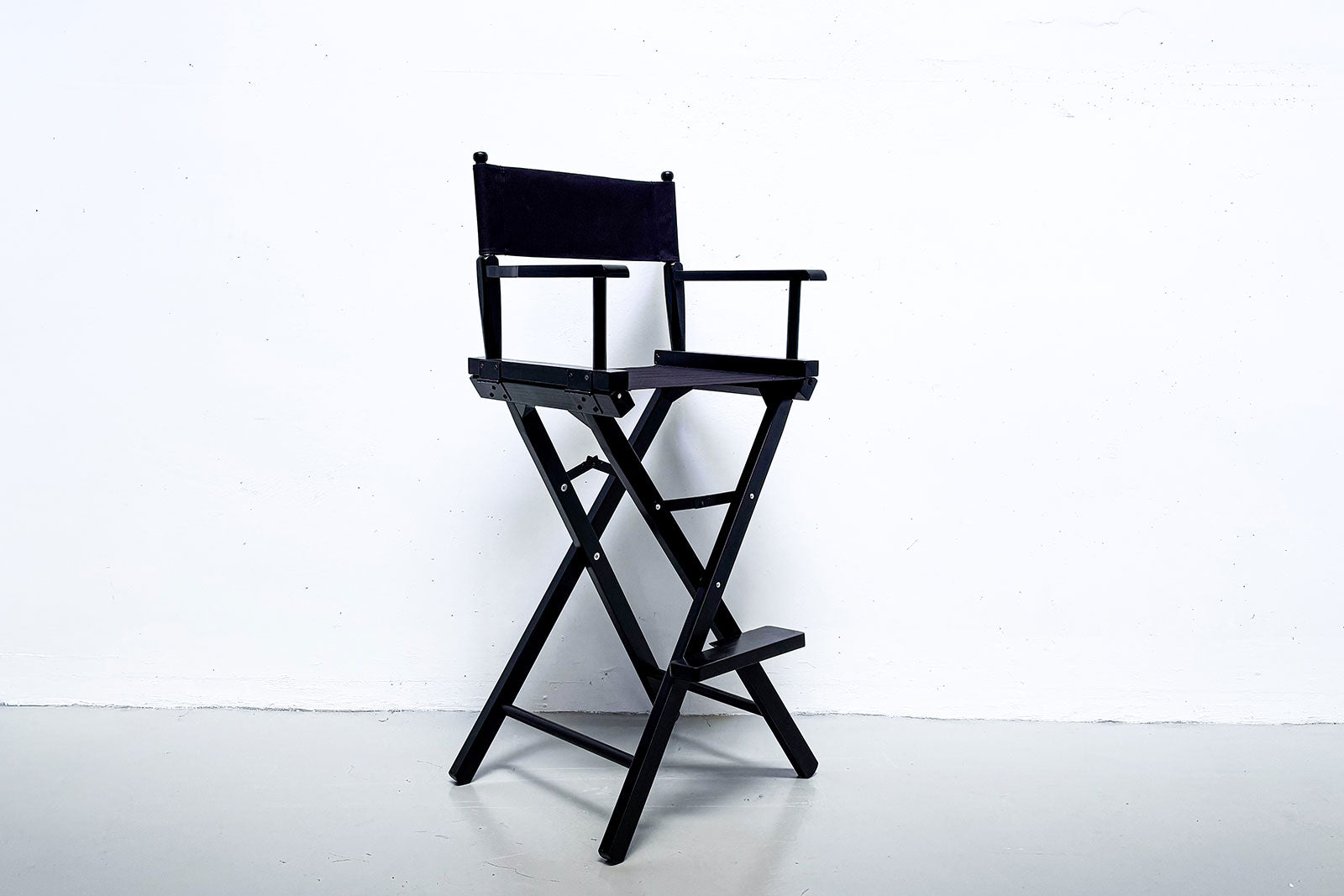 Black and timber director chair for hire at corporate event and media wall setup in Auckland.