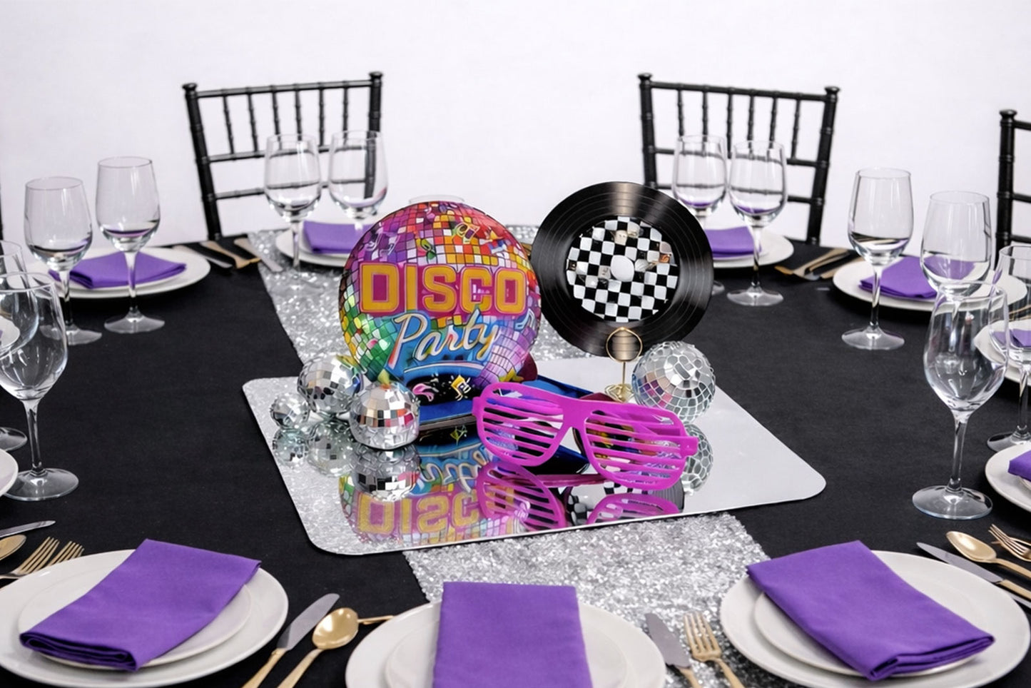 Vibrant disco-themed centrepiece featuring sparkling disco balls and colorful retro decor for party tables