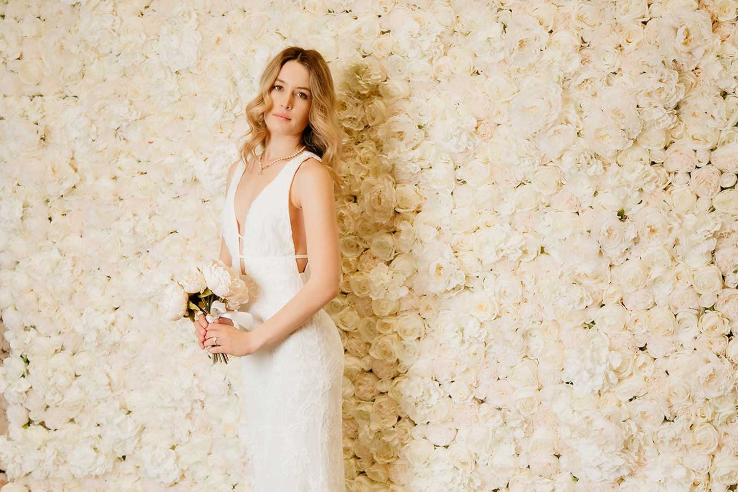 Elegant white flower wall used as a wedding photo backdrop