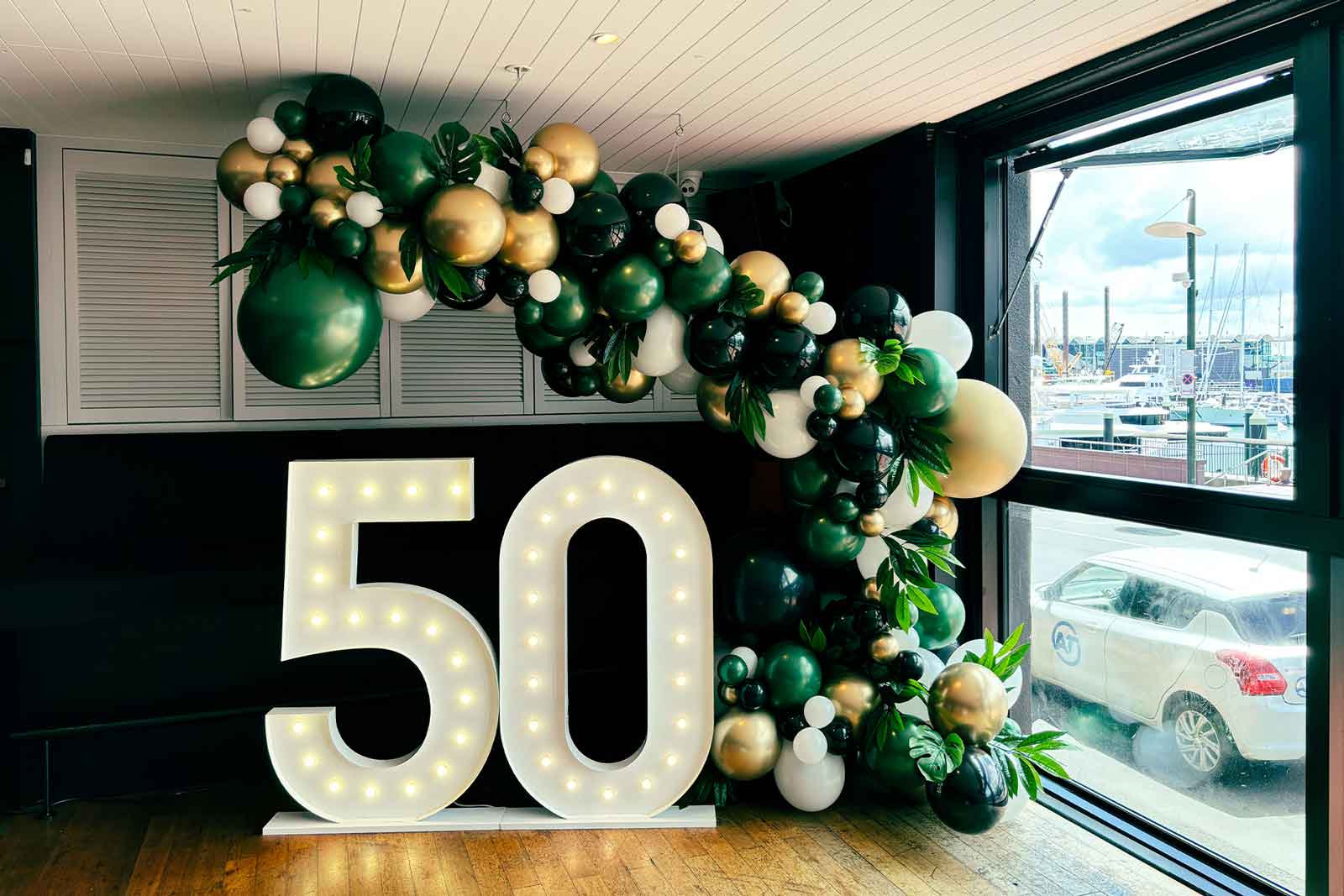 Balloon décor installation with bright light-up number props