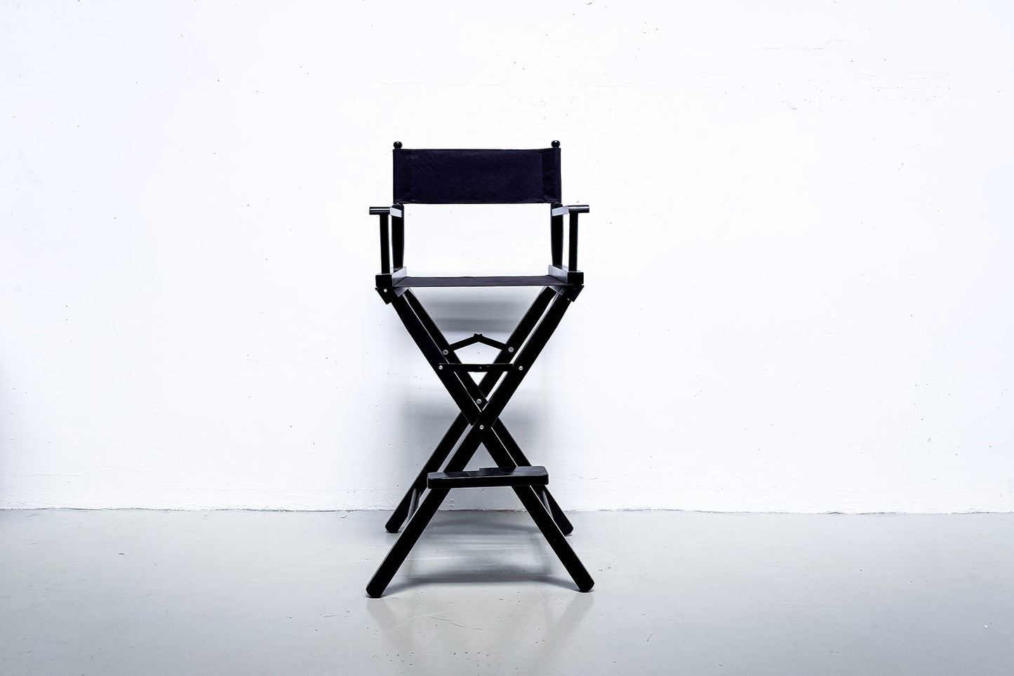 Freestanding director chair styled with event backdrop and balloon garland for celebration hire in New Zealand