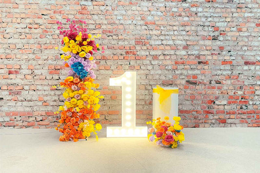 First birthday backdrop with elegant floral styling, marquee lights and balloon garland for a beautiful birthday celebration in Auckland, NZ.
