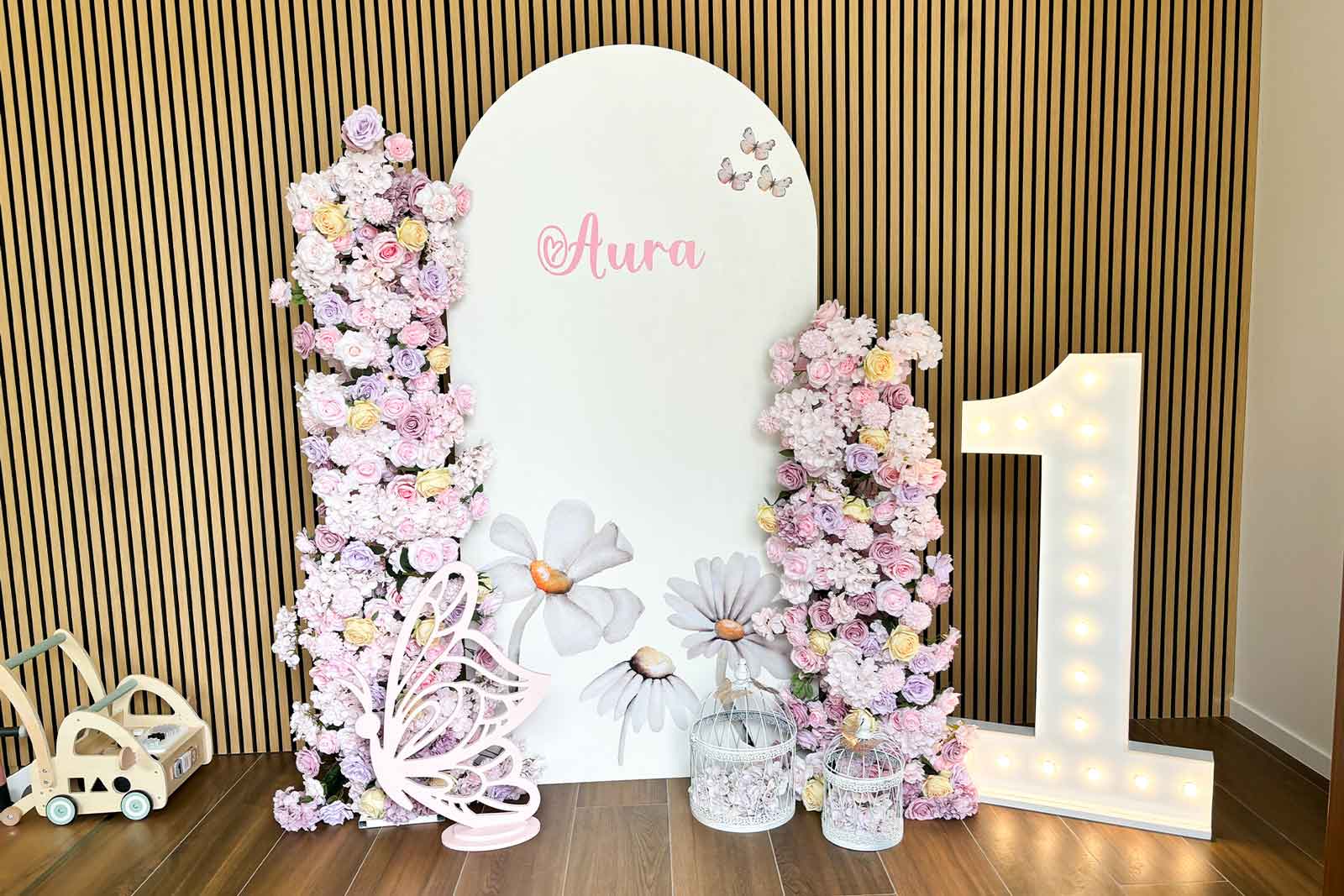 Arch backdrop stand covered with artificial florals for 1st birthdays