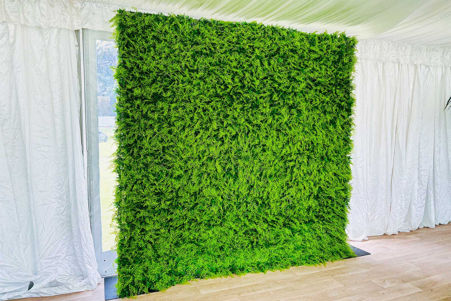 Lush green wall backdrop used for corporate event styling and photo opportunities in New Zealand.