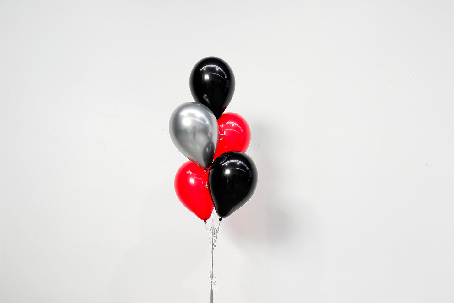 Colourful helium balloon bunch floating above a weighted base, perfect for birthdays, corporate events, weddings, and celebrations in Auckland.
