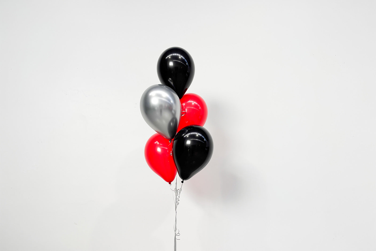 Colourful helium balloon bunch floating above a weighted base, perfect for birthdays, corporate events, weddings, and celebrations in Auckland.
