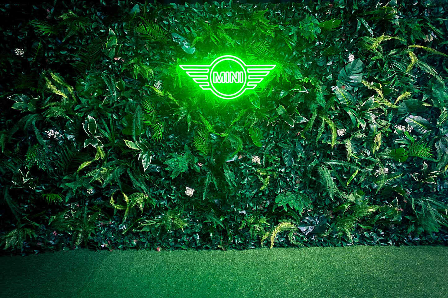 Island-themed greenery wall backdrop with tropical foliage for stylish event decoration and photo opportunities