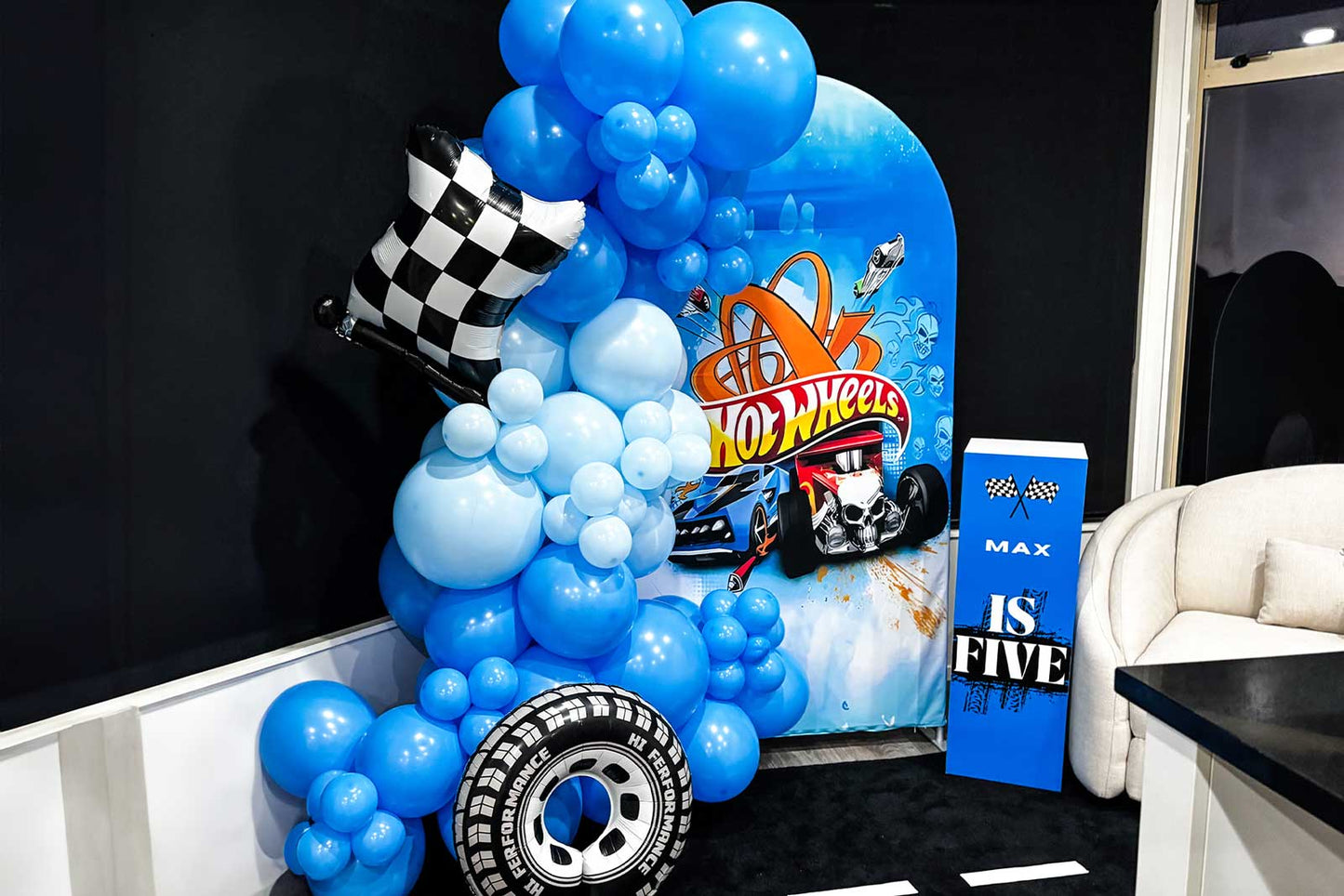 Themed kids party backdrop hire with colourful balloons and props and custom plinth