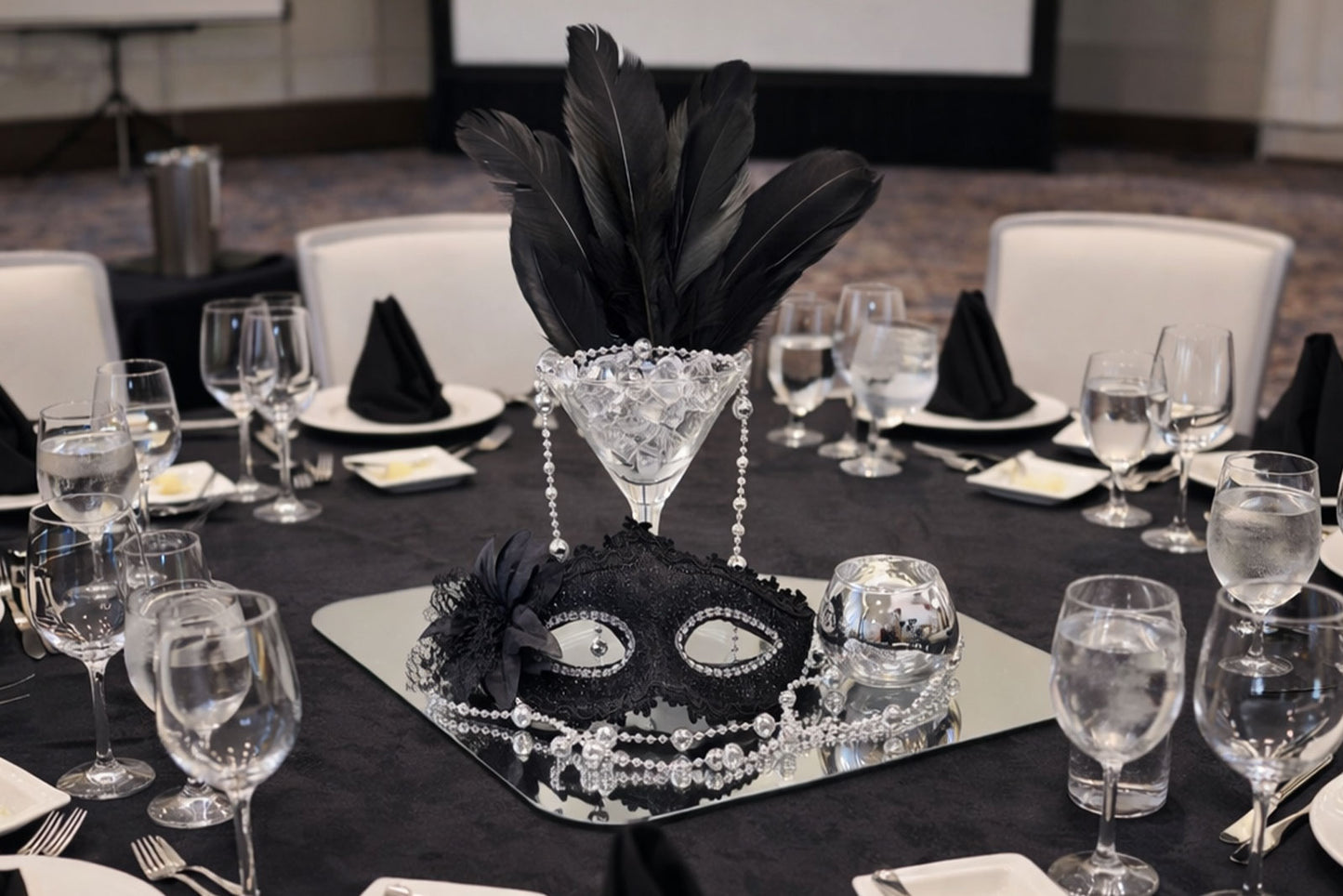 Luxury masquerade ball table centrepiece with feathers and metallic accents in New Zealand