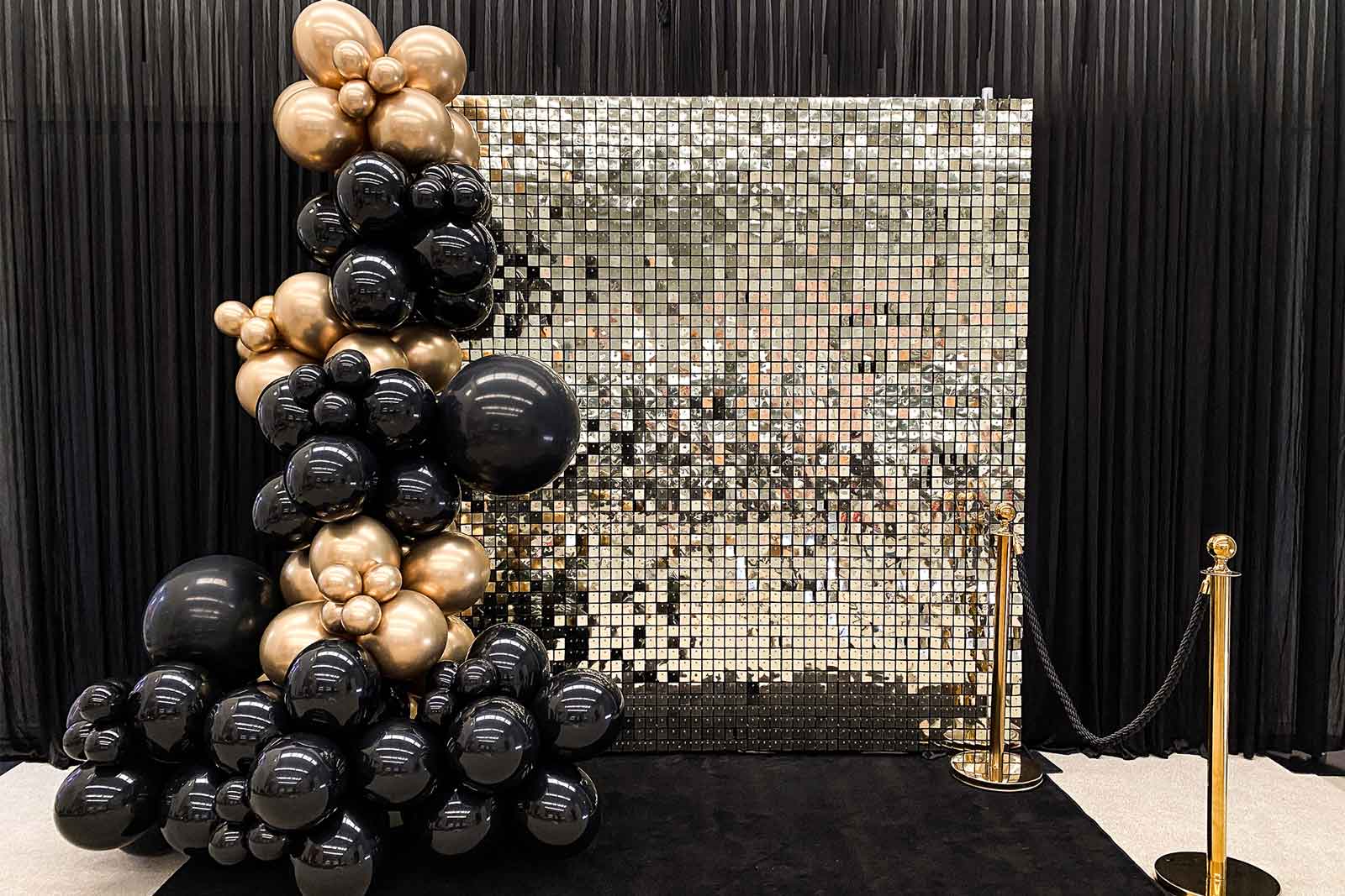 Milestone 50th celebration featuring marquee numbers, black and gold balloons, and a shimmer wall backdrop