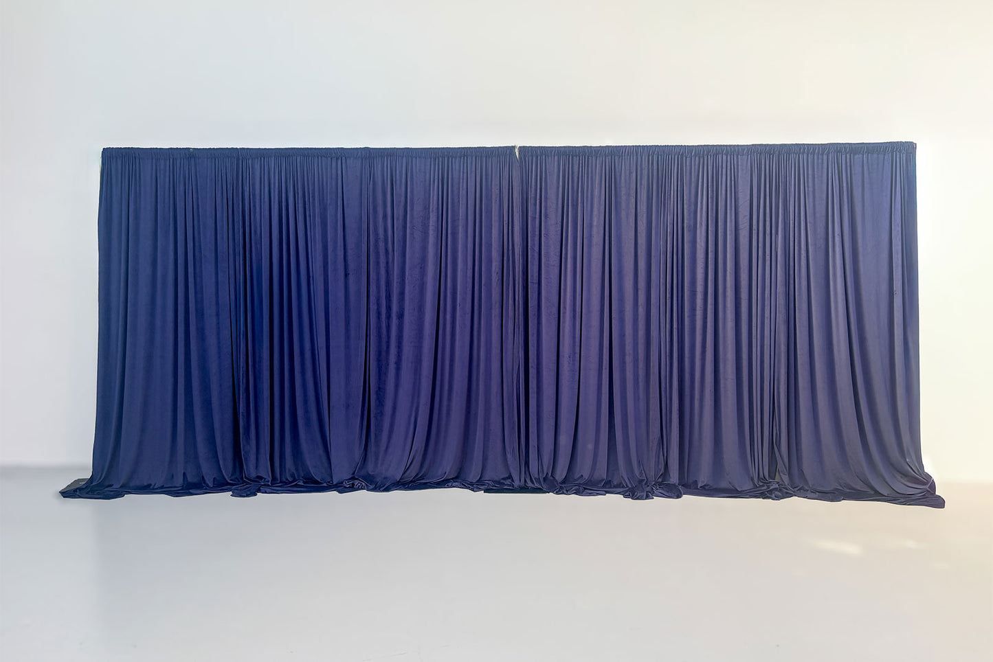 Navy velvet draping backdrop with soft gathered folds, ideal for event styling and photo backdrops.
