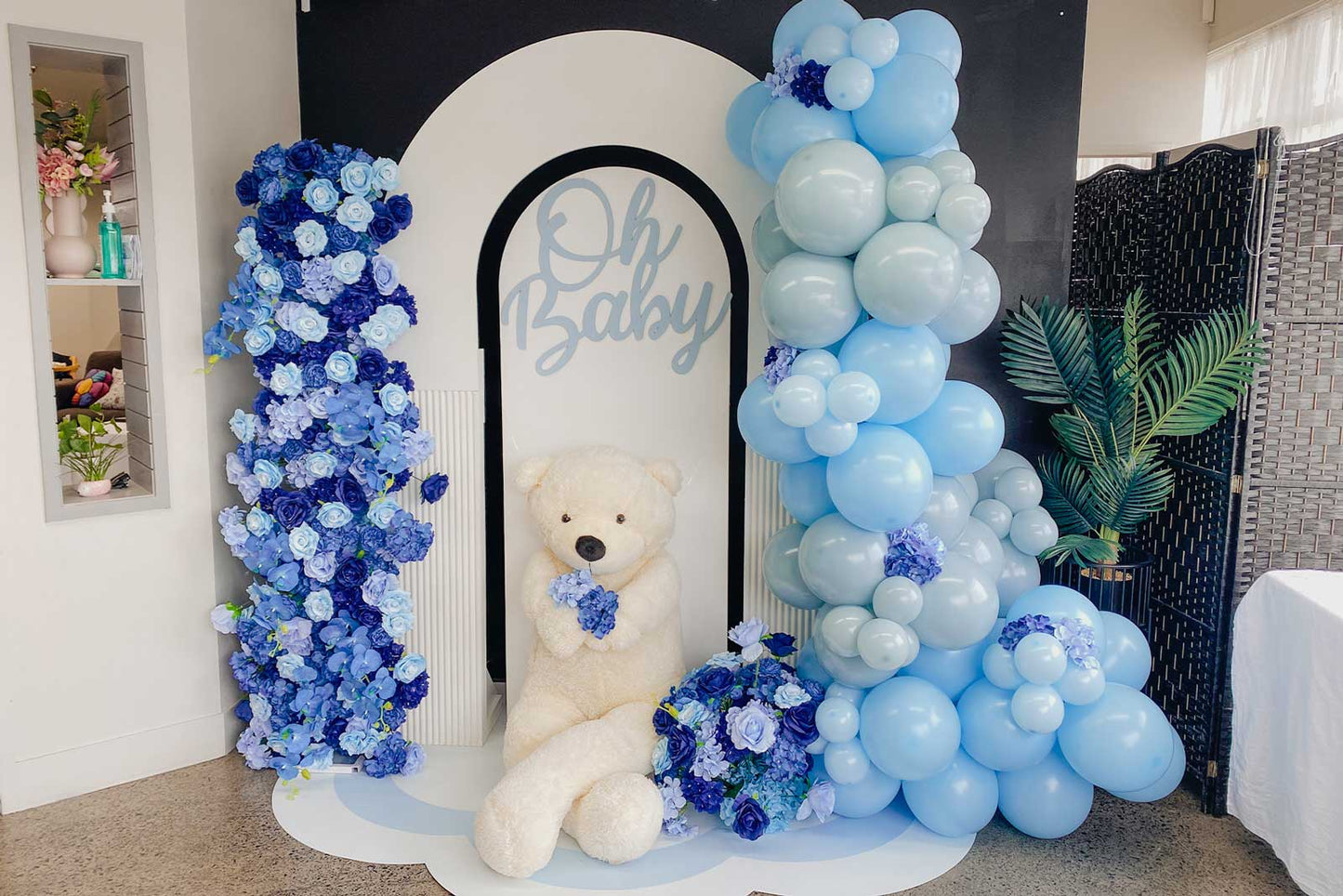 Luxury "Oh Baby" backdrop with blue balloon garland, elegant floral arrangements and premium baby shower styling for unforgettable celebrations in Auckland, NZ.