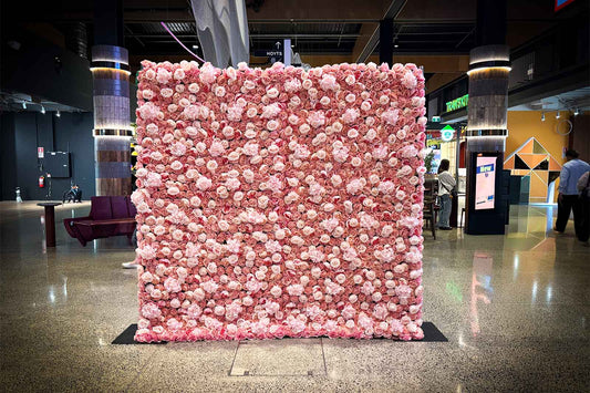 Pink flower wall backdrop for hire, perfect for 21st weddings, events, and photo opportunities, featuring lush floral panels for a soft, elegant display.
