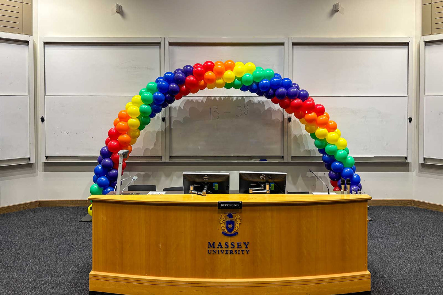 Colourful spiral rainbow balloon arch creating a vibrant entrance for Pride celebrations, festivals, corporate events, schools and community events across Auckland.