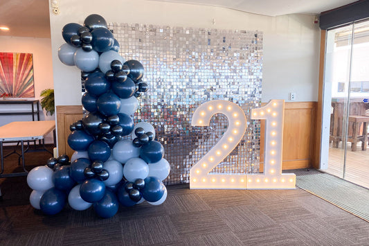 Silver shimmer wall backdrop with 21 marquee lights for a fun and stylish 21st birthday