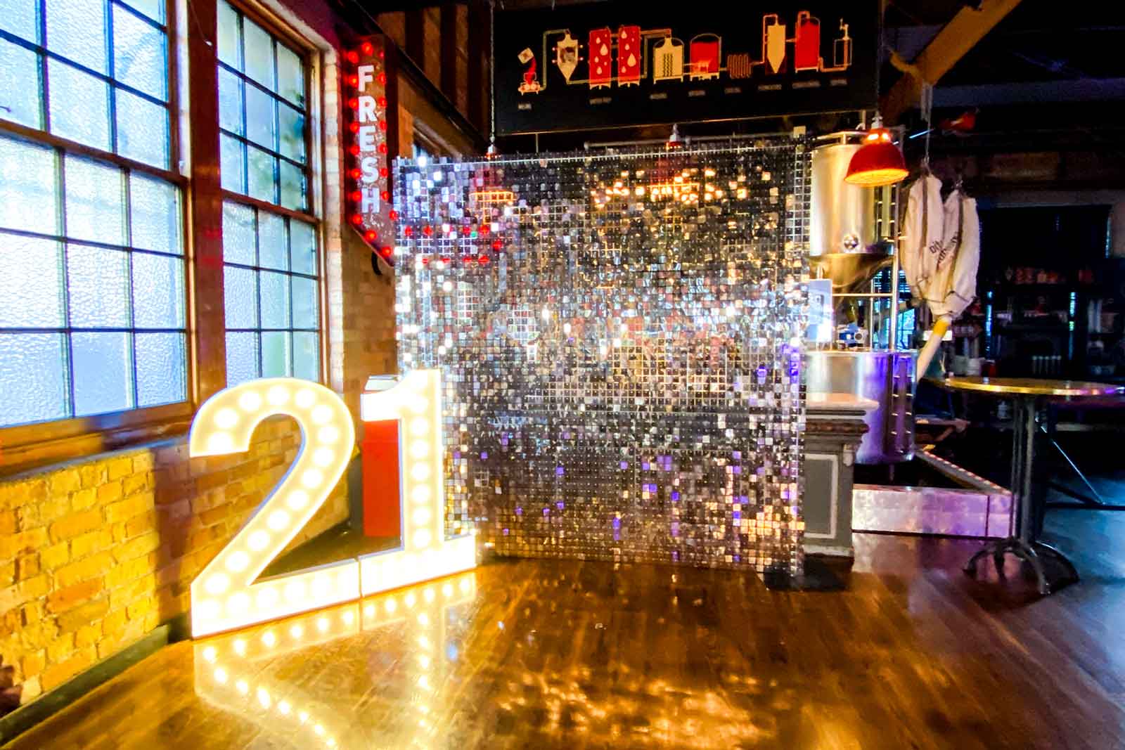 Silver shimmer wall featuring 21 glowing marquee lights for milestone celebrations