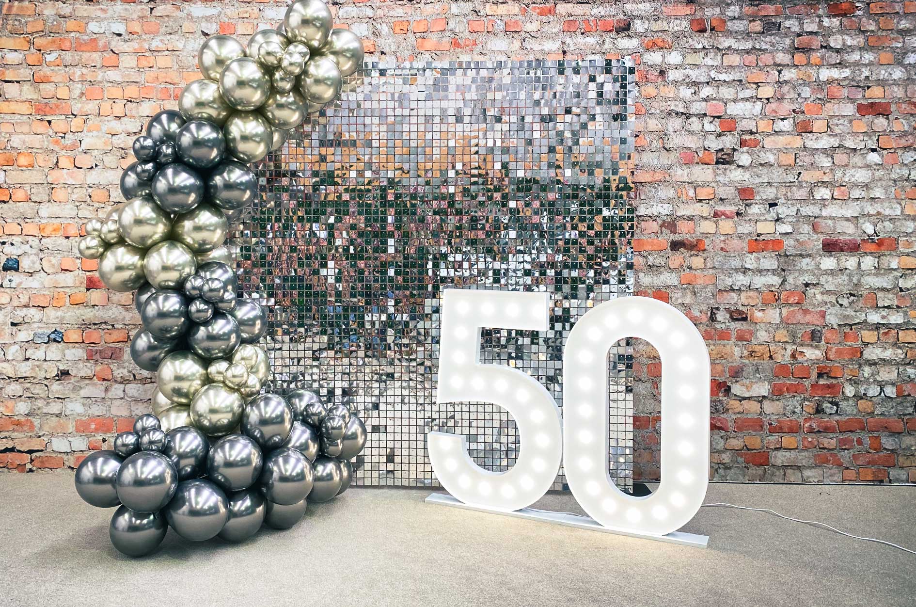 Silver shimmer wall backdrop featuring 50 marquee lights creating a glamorous photo area for events