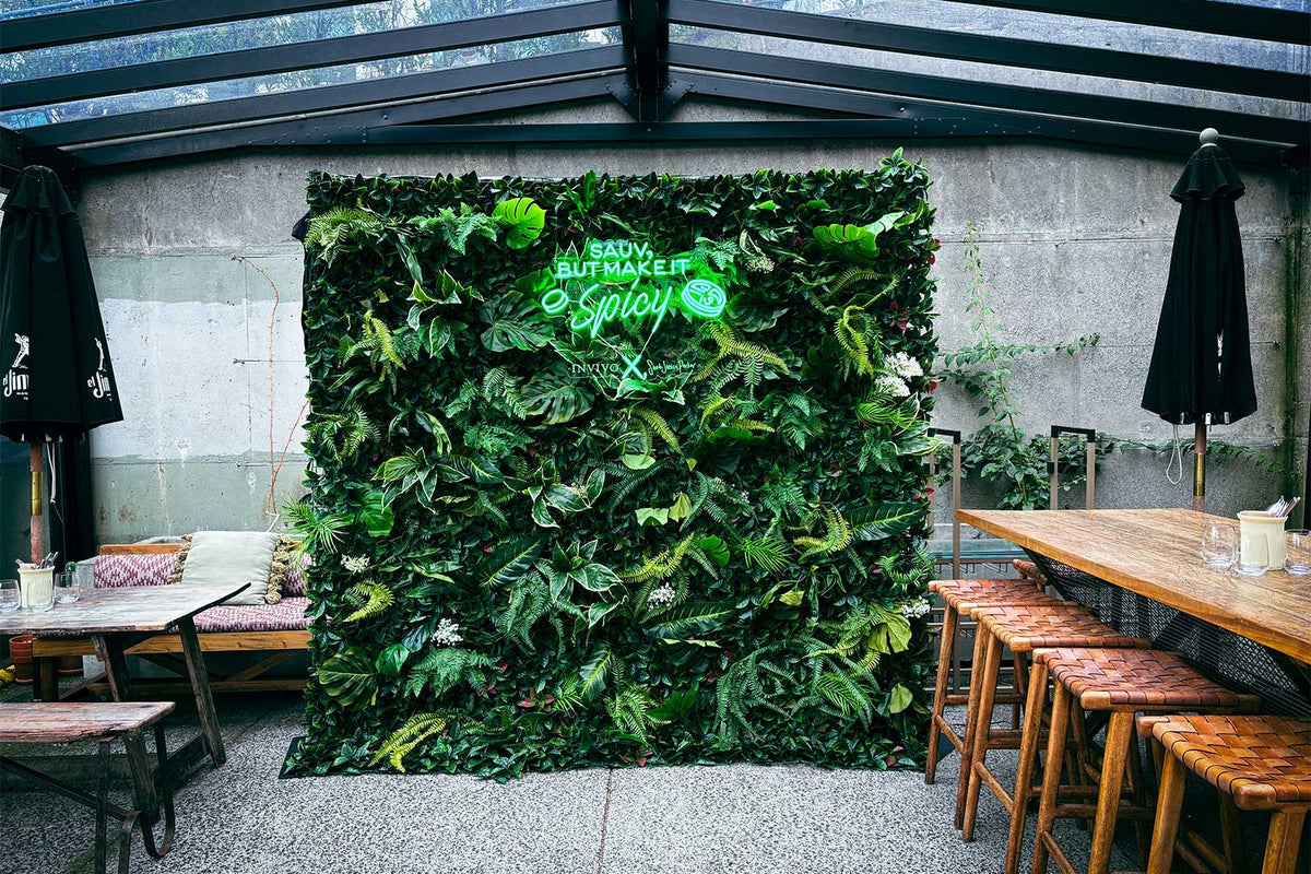 Tropical green wall with custom neon sign for event styling and backdrop hire