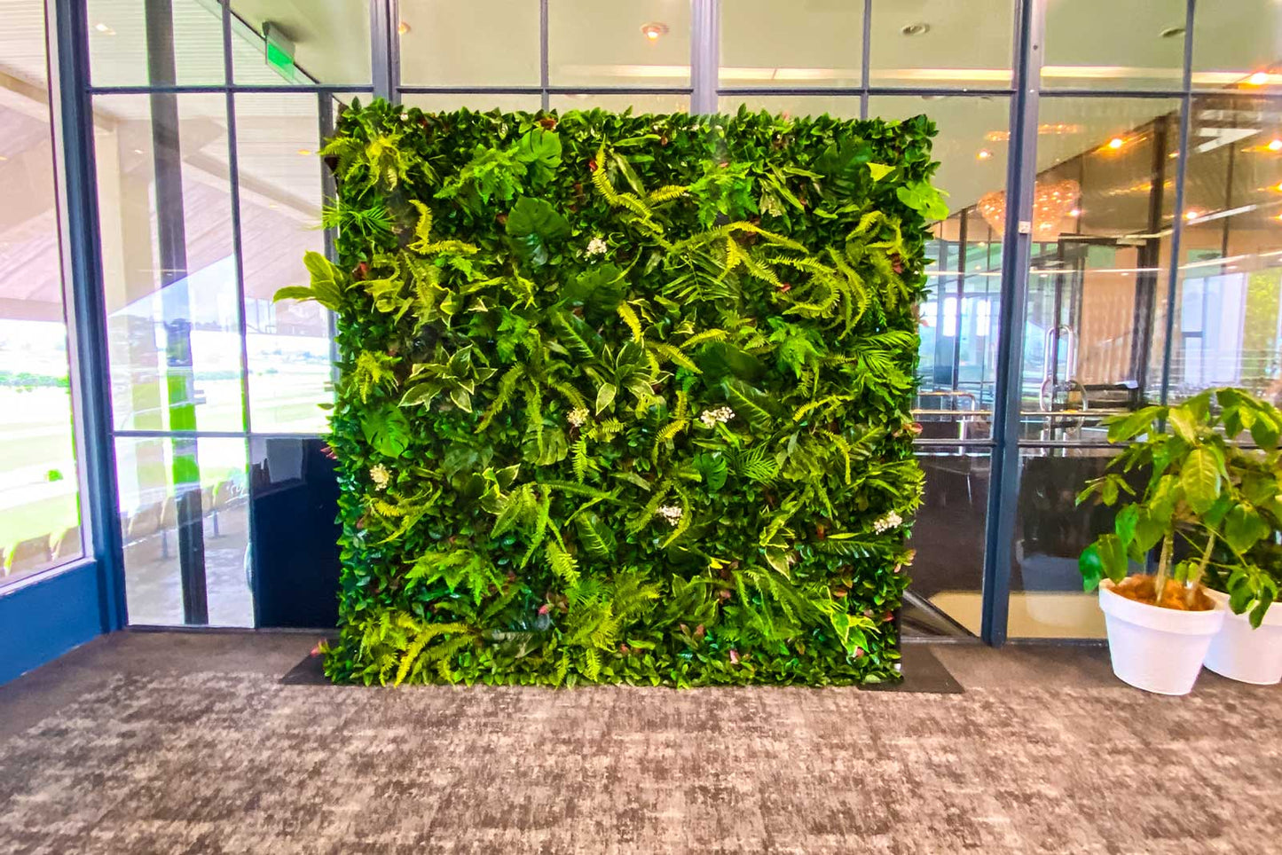 Tropical greenery photo wall backdrop providing a vibrant setting for event photos and styling