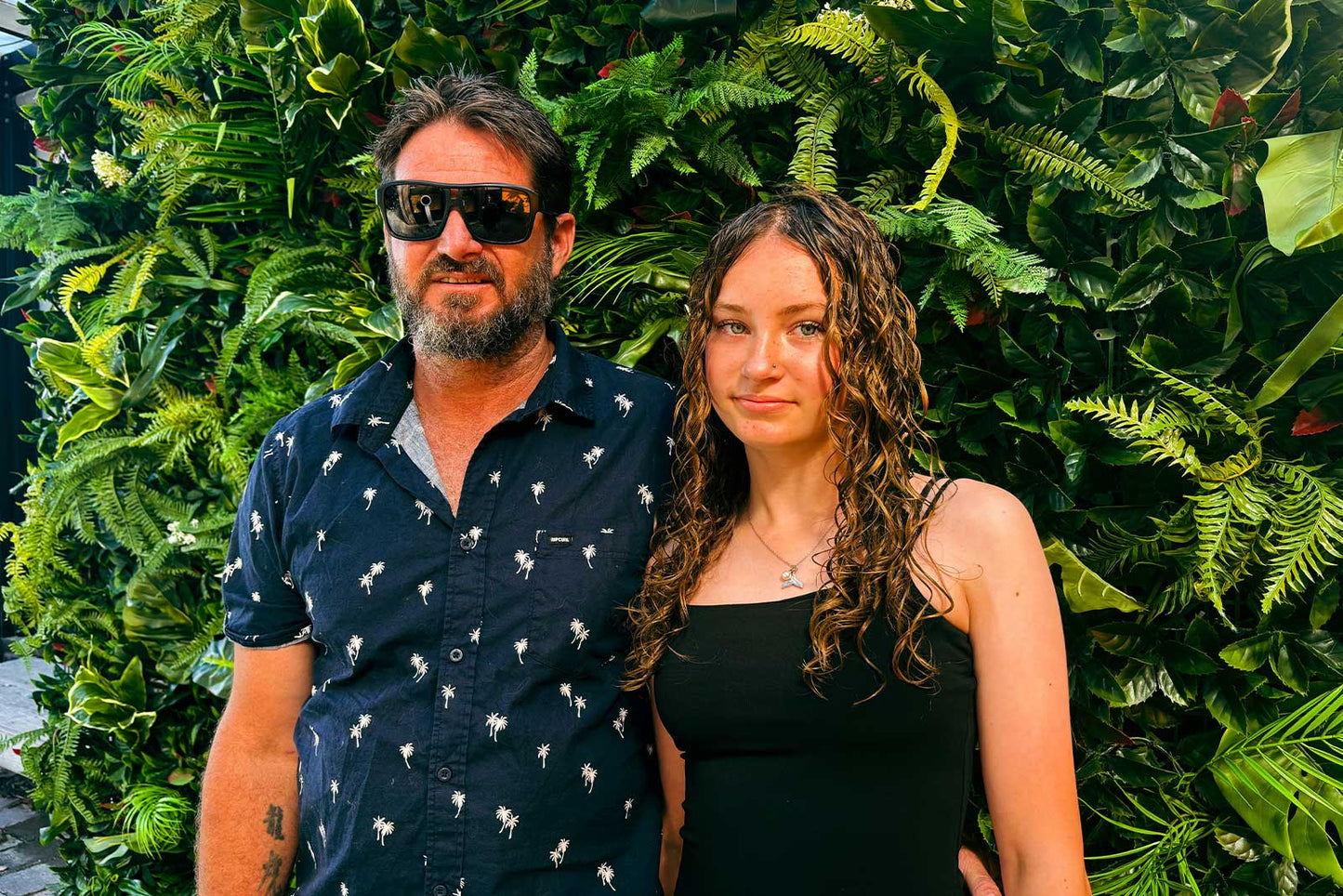 Tropical wall backdrop with lush greenery and balloon styling for graduation celebration