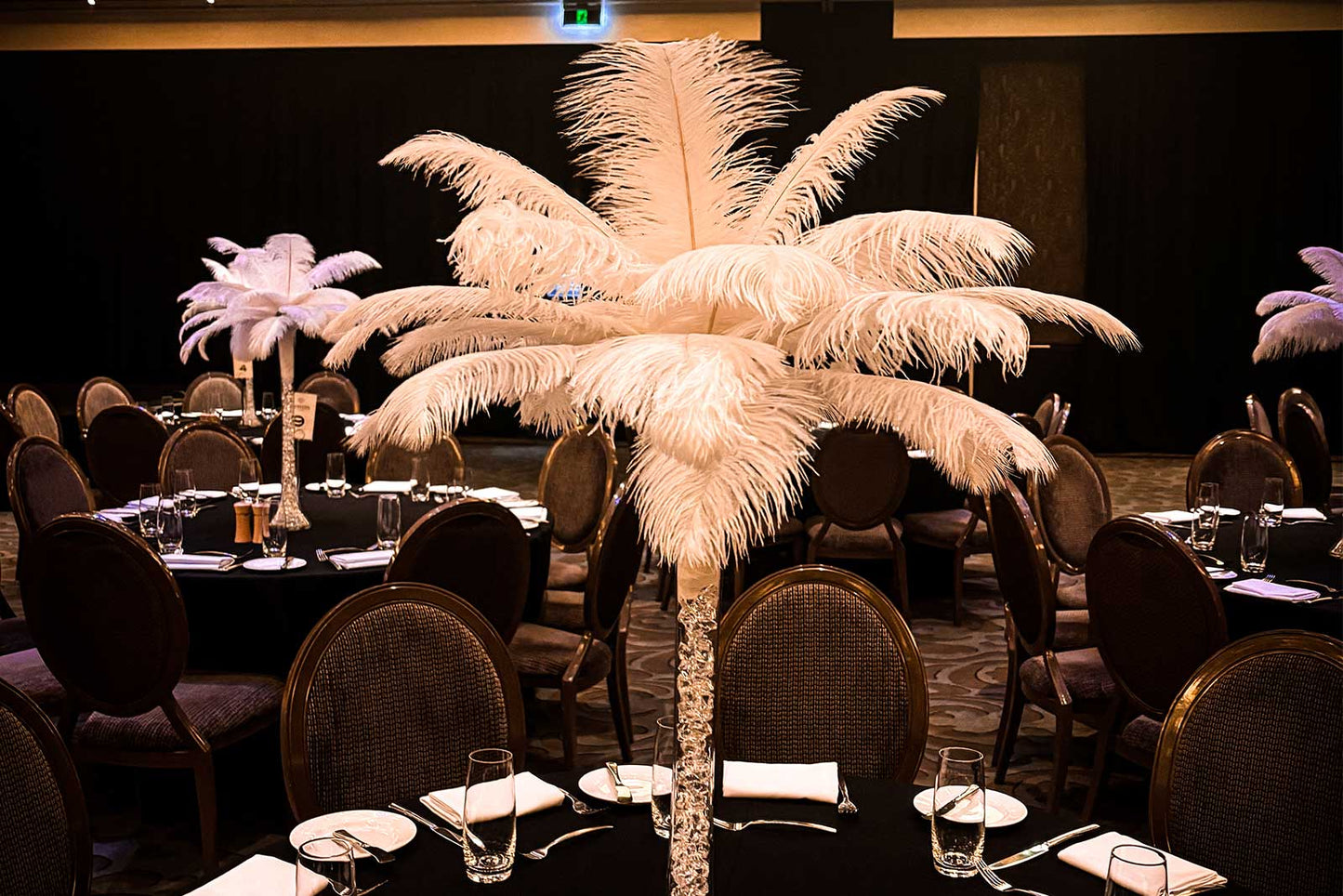 White feather centrepiece styled on an event table for a luxury wedding or corporate function in Auckland