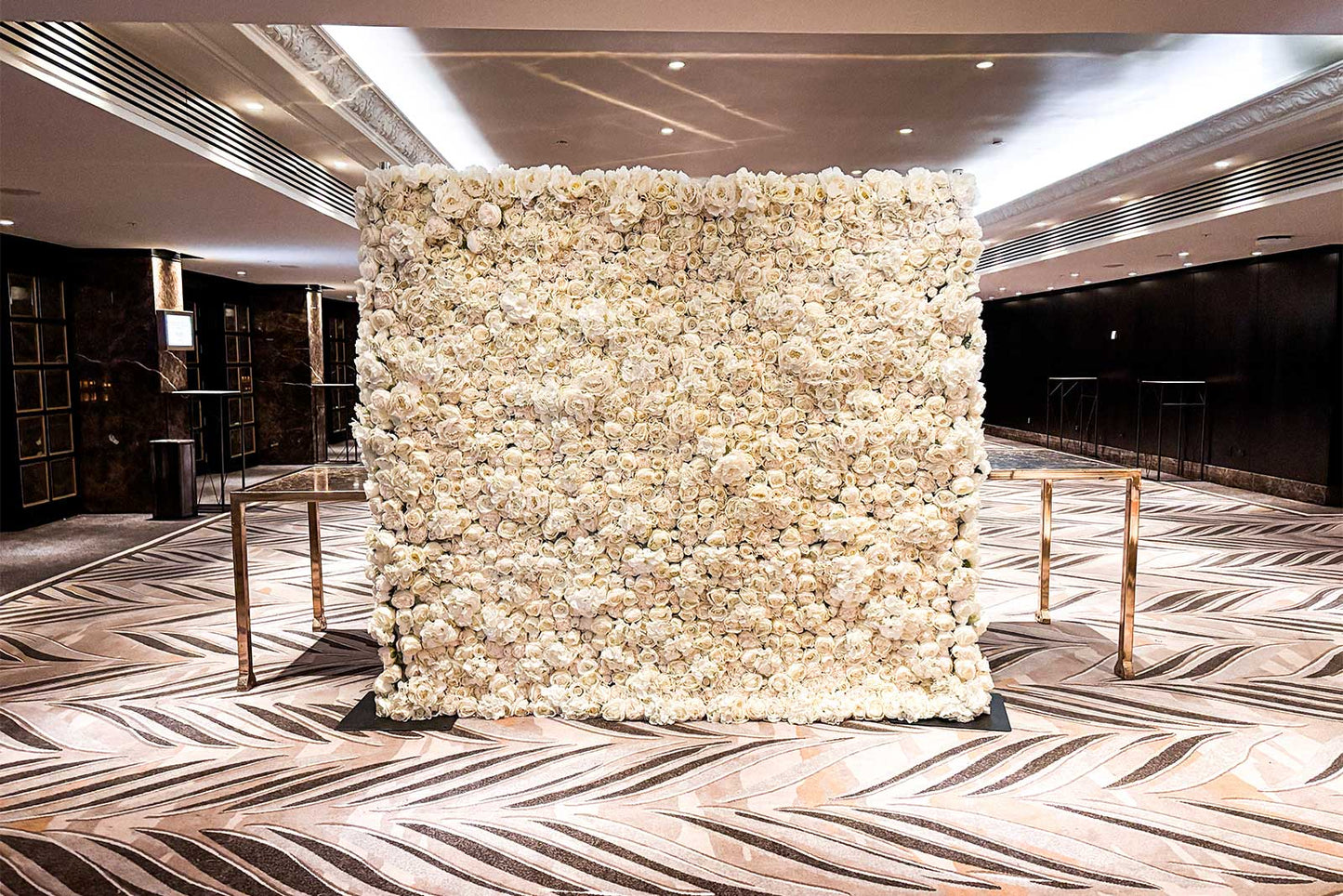 Elegant white flower wall backdrop for wedding ceremony and reception hire in Auckland, New Zealand.