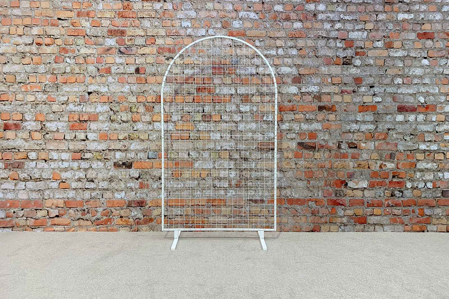 White mesh arch backdrop creating a clean and modern photo area for events