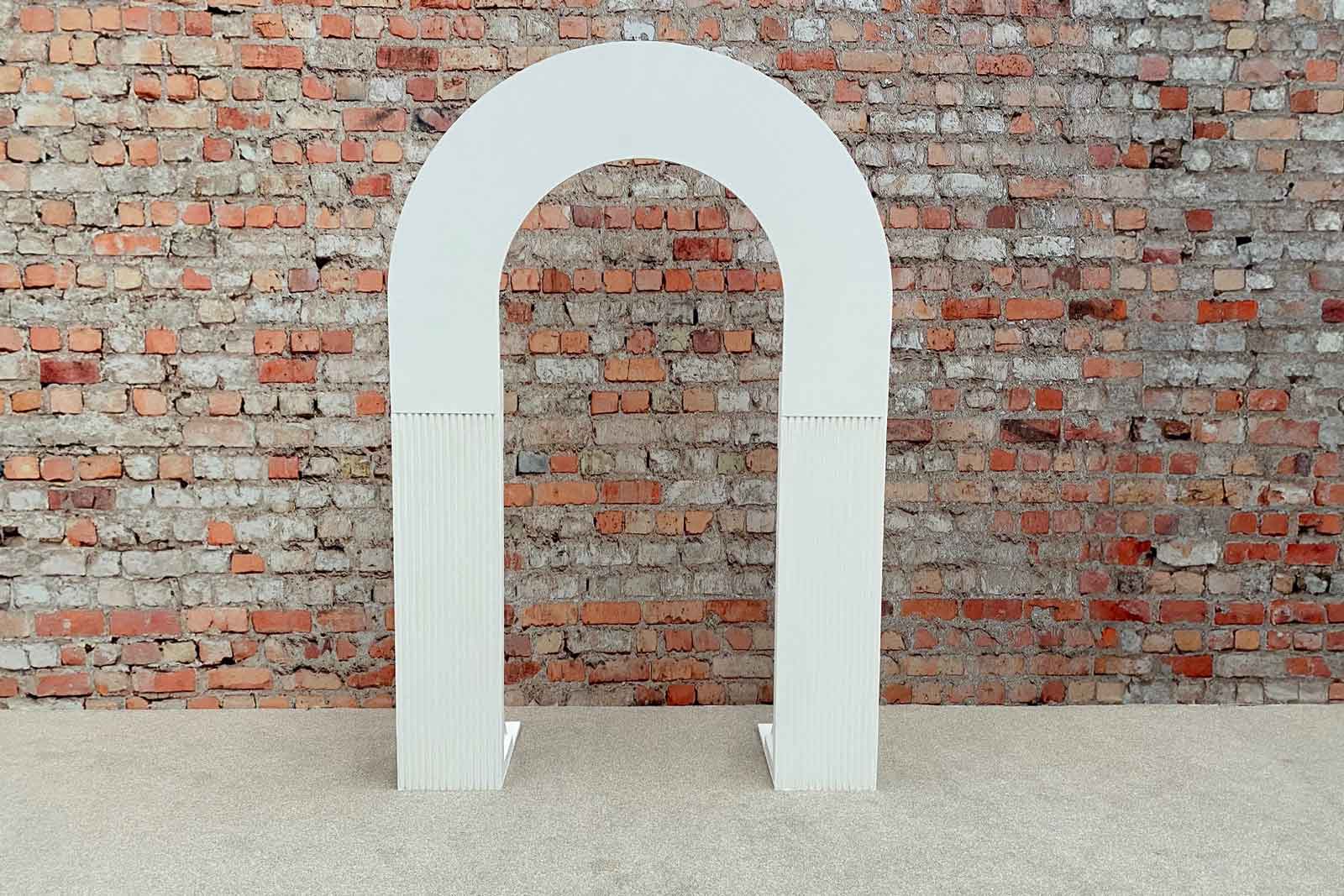 White ribbed half arch backdrop creating a modern and stylish photo area for events