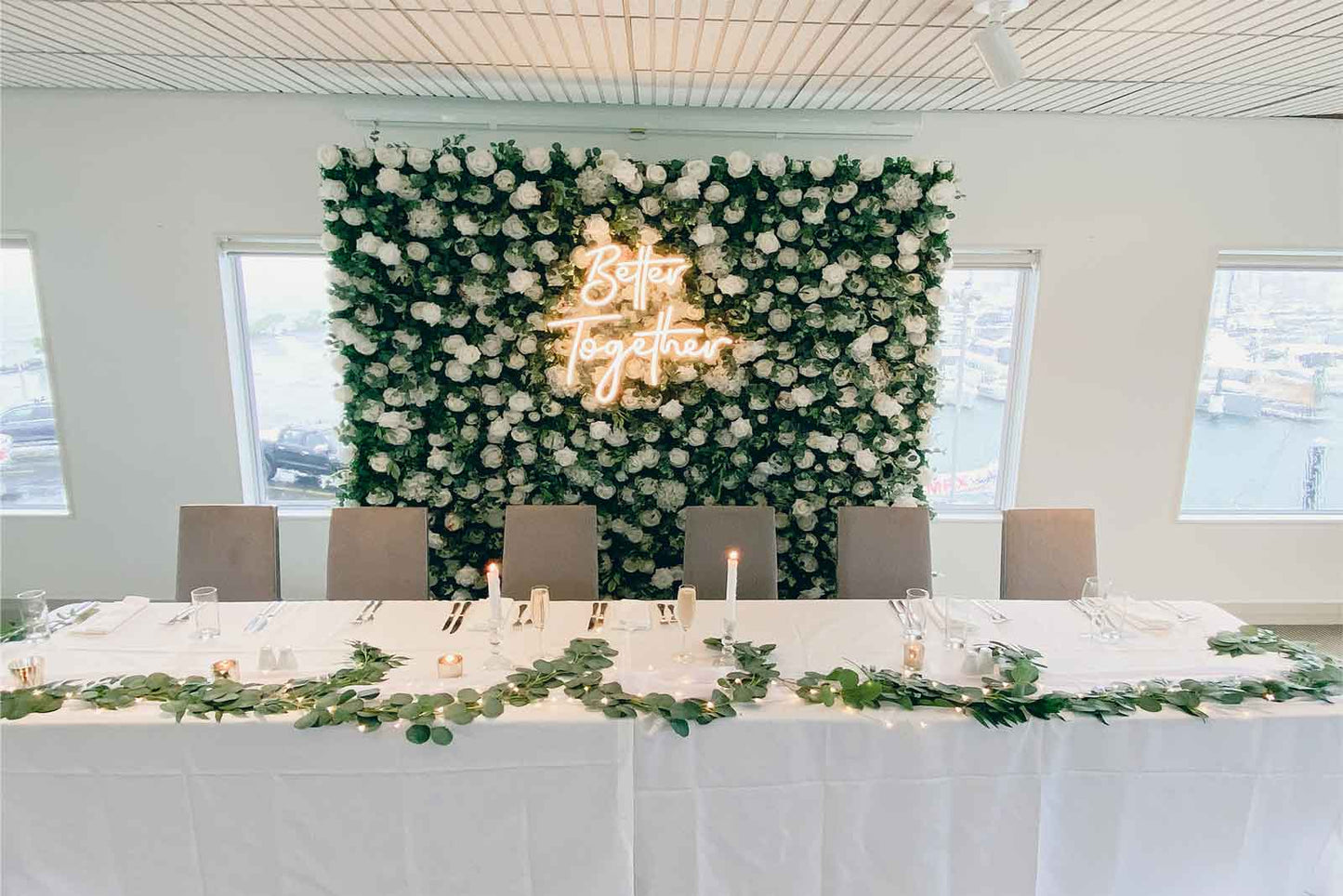 Custom wedding flower wall with "Better Together" neon sign for ceremony and reception décor