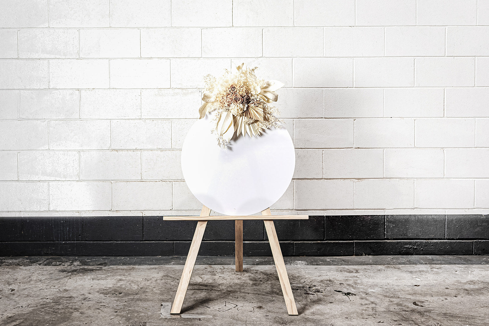 Decorative white acrylic disc on easel for event signage or photo displays