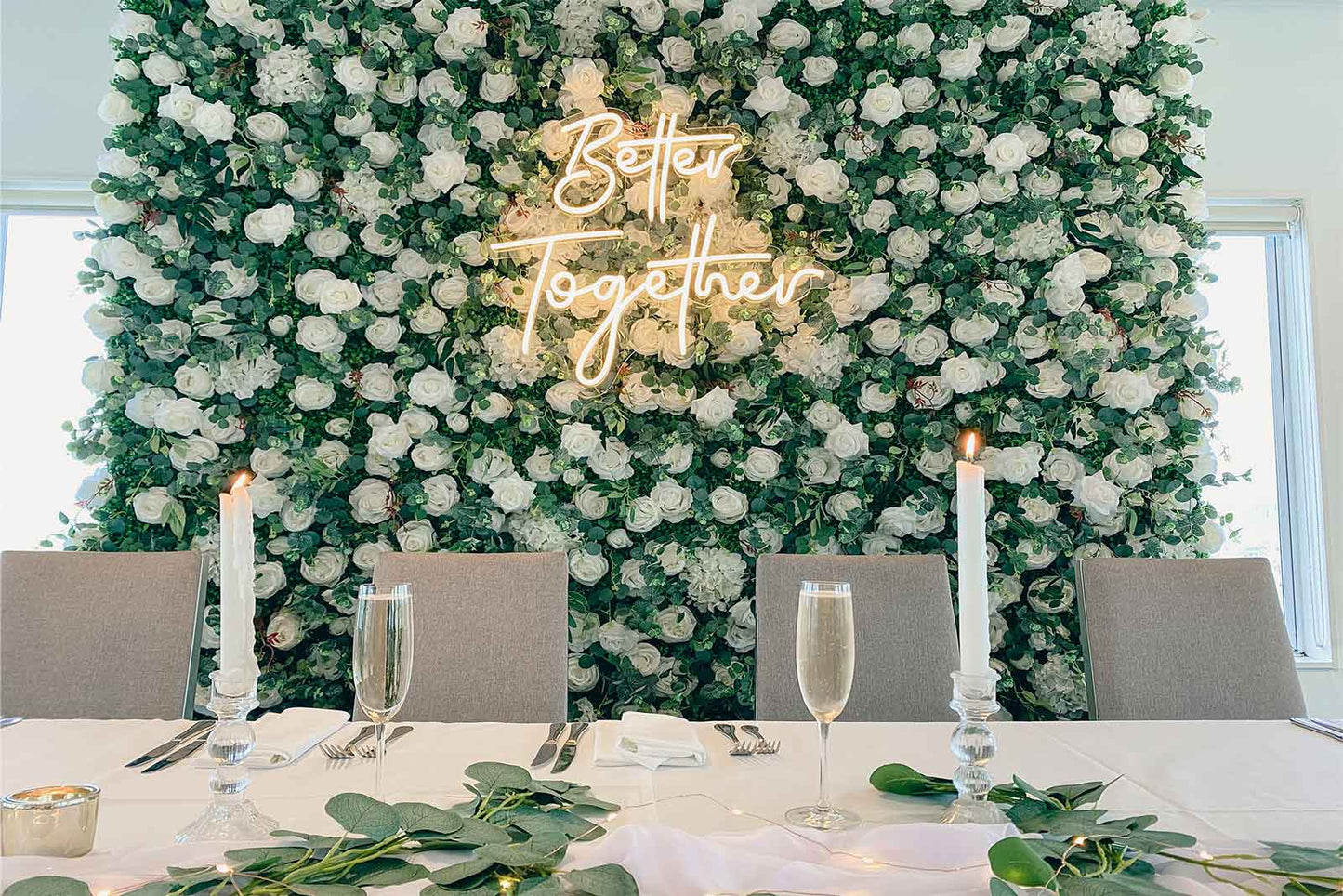Elegant wedding flower wall featuring "Better Together" neon sign for reception backdrop