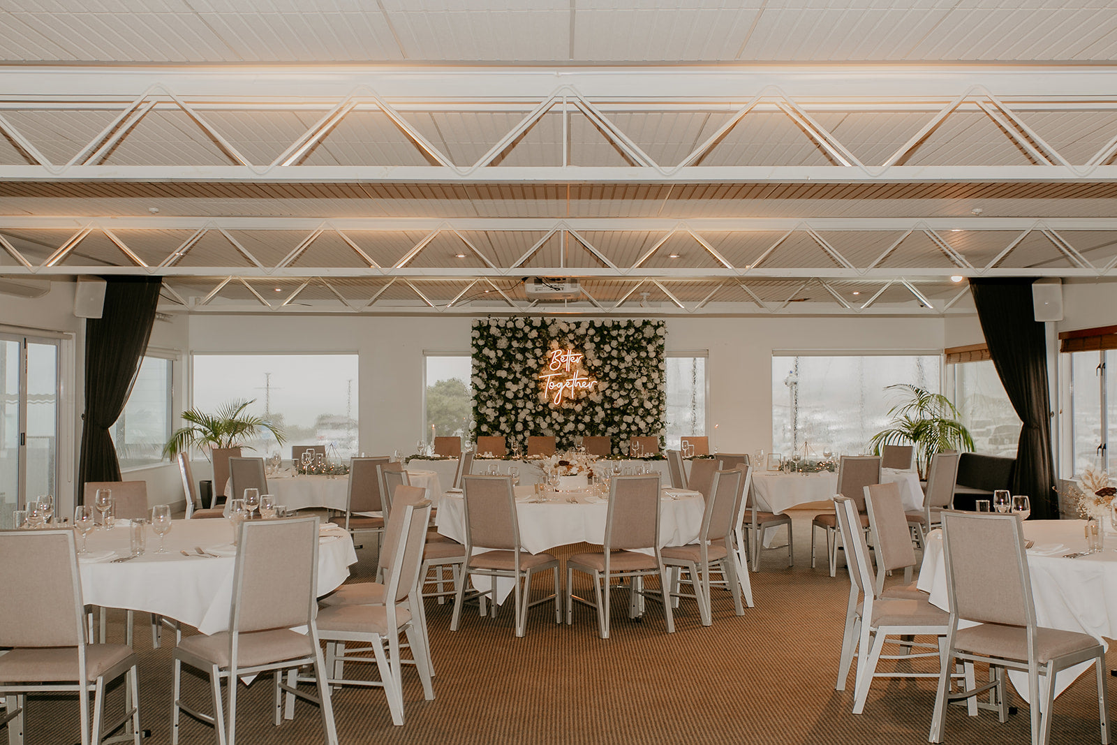 Floral wedding wall backdrop with glowing "Better Together" neon sign for romantic celebrations