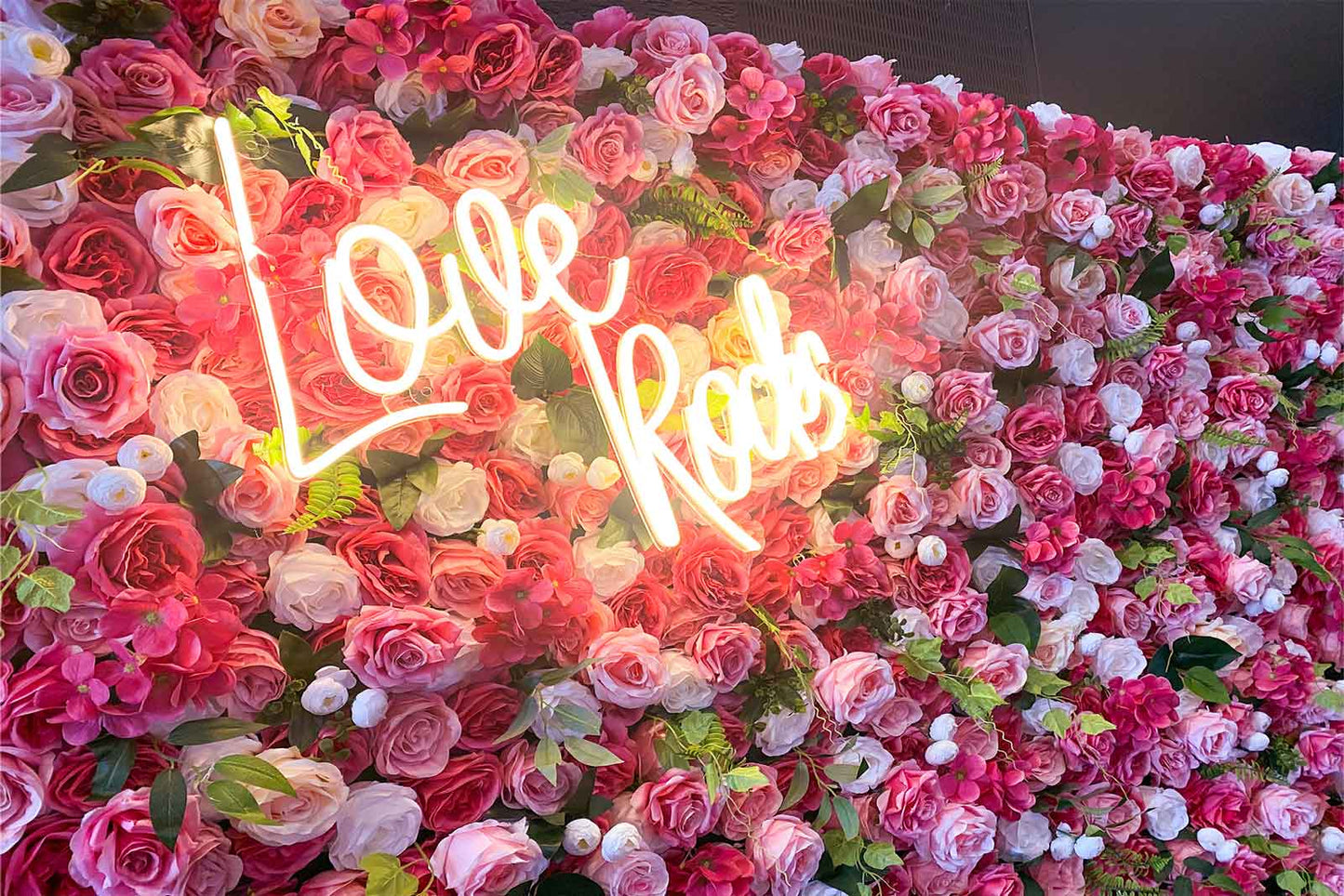 Pink and white floral backdrop wall for party and event photography with neon sign